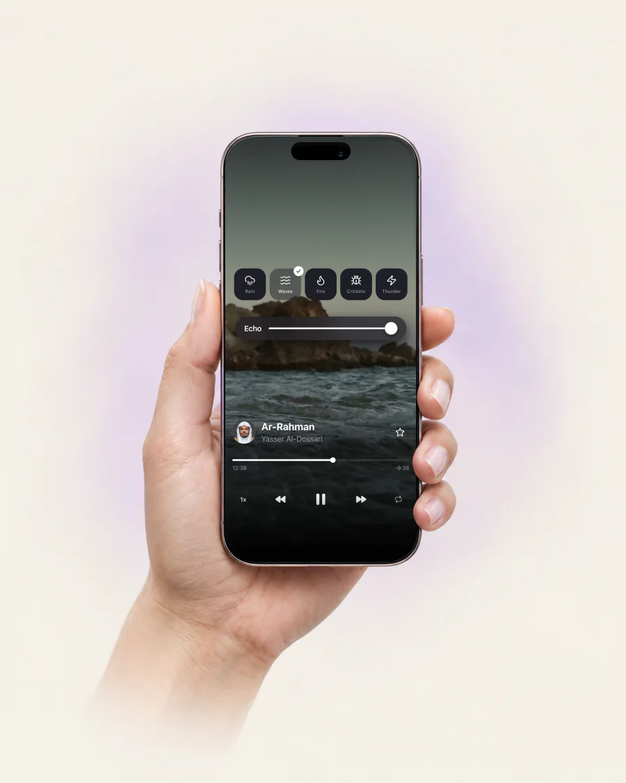 A hand holding an iPhone showing the audio player of Quran Breeze.